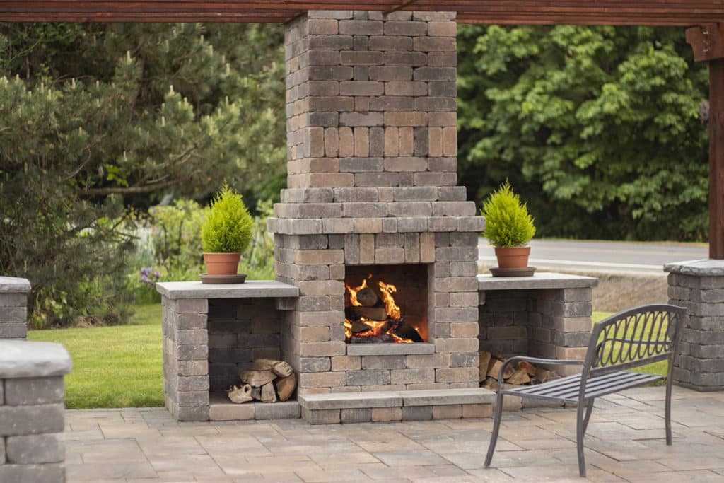Custom Chateau Wall™ Columbia Blend fireplace with La Pietra™ Columbia Blend patio wood arbor trellis pergola