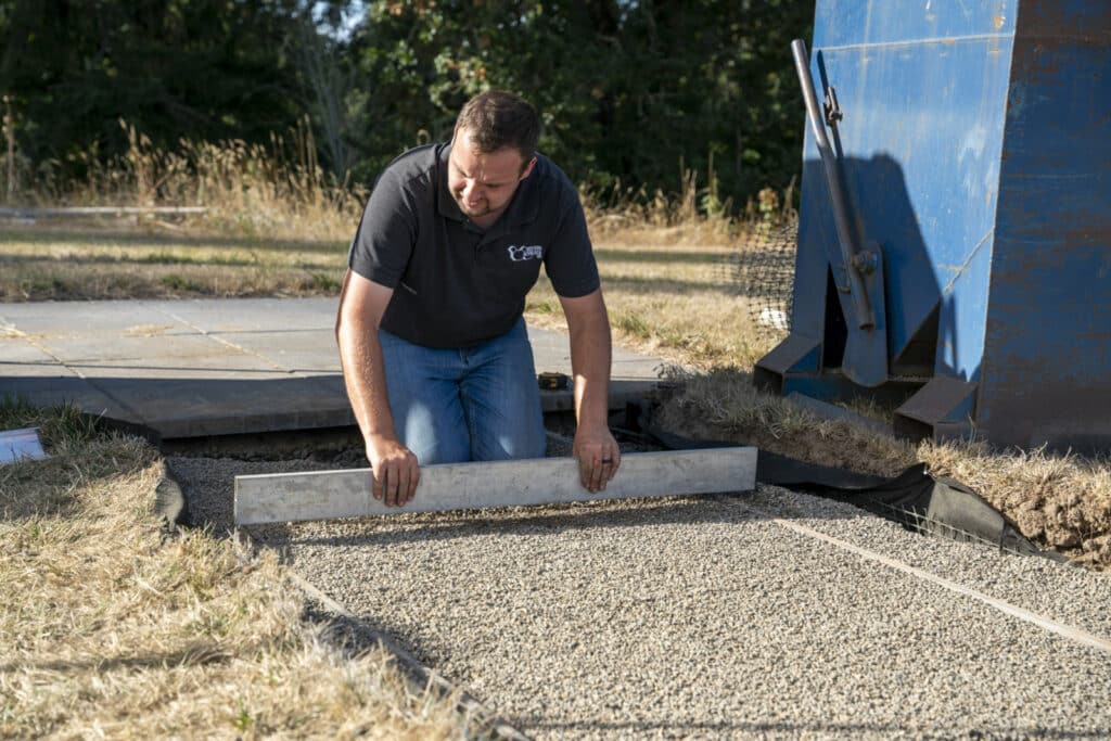 Leveling the bedding layer with a screed board for a smooth paver surface