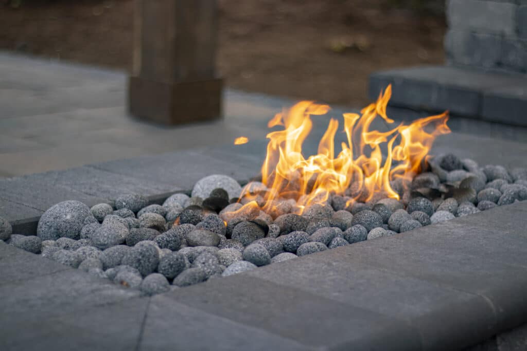 Gas fire pit with lava pebbles and Western Interlock Monaco Coping stones