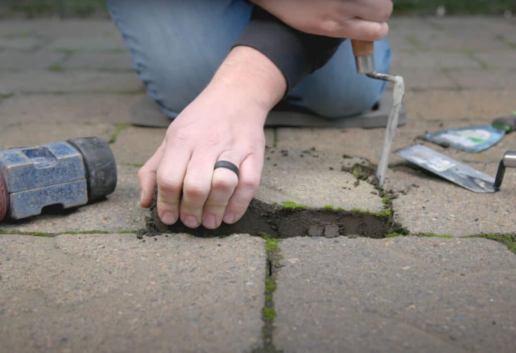 Carefully removing paver stone with rubber mallet in view